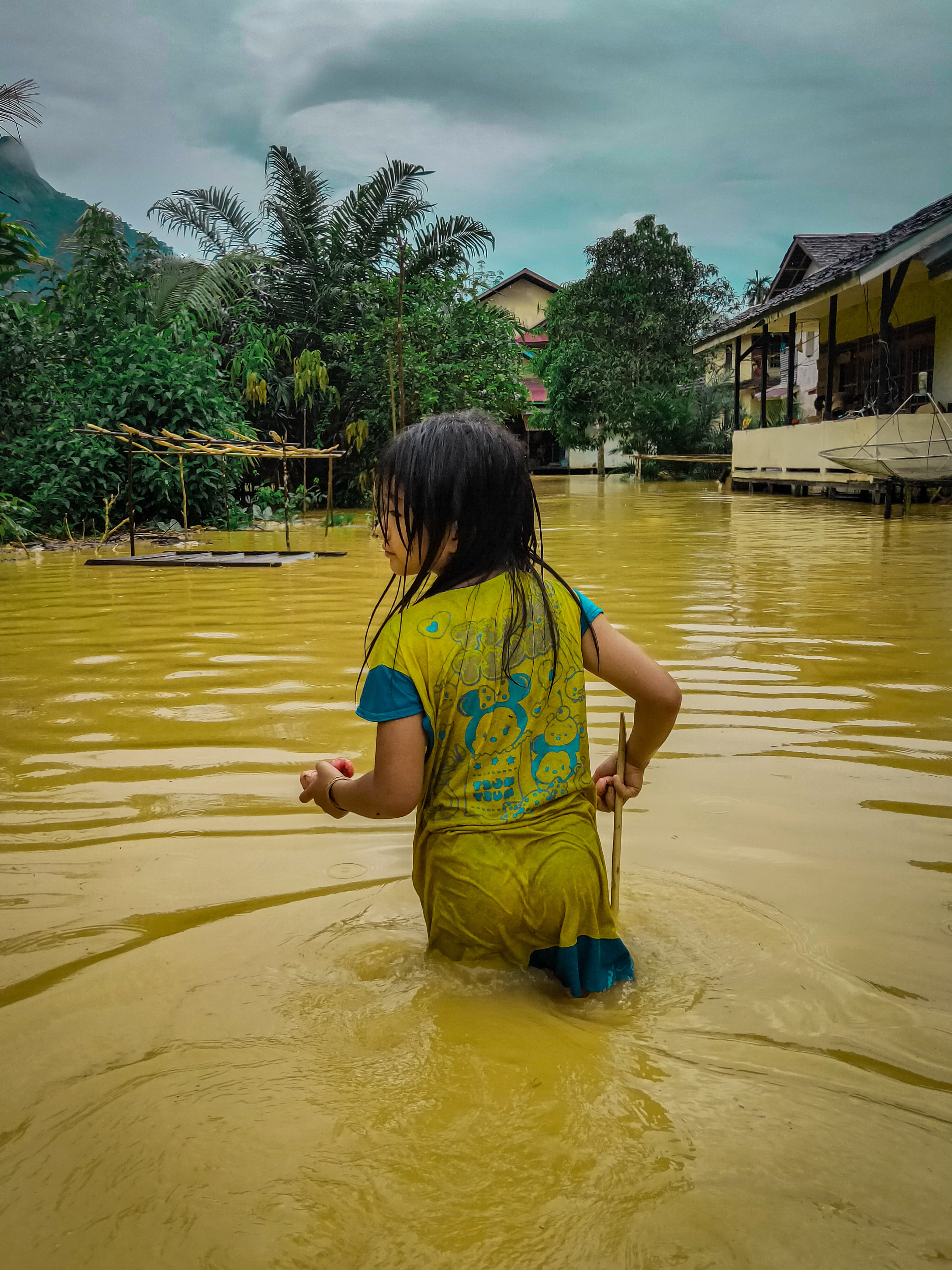 Girl in Blue and Yellow Shirt Standing on Yellow Water Photo: Yohanes Deobi on Pexels