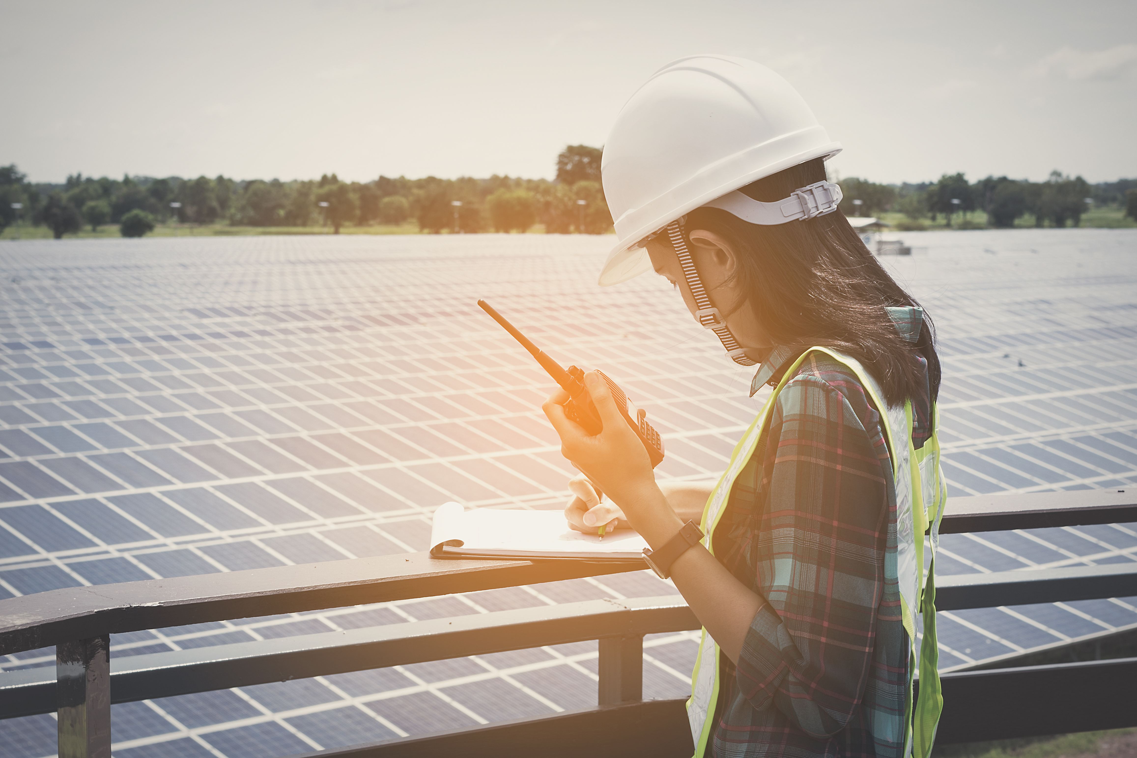 A woman checks data from solar panels. Photo by shutterstock.